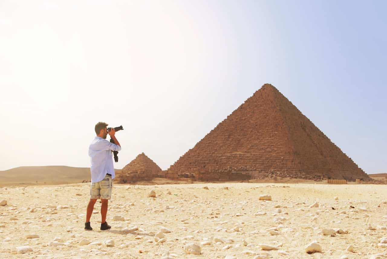 our-experience Photographer taking a picture of the Pyramid of Giza under the bright Egyptian sun.