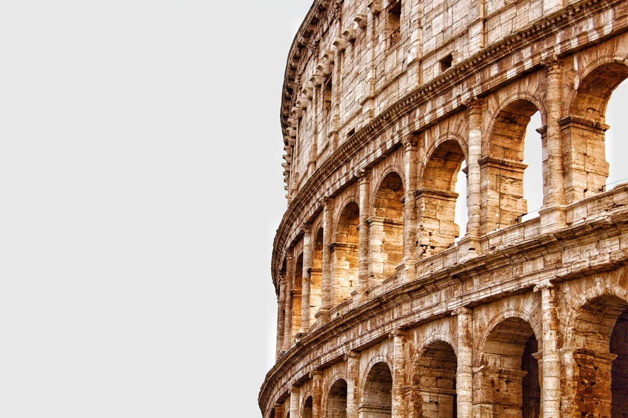 ours-journey Detailed view of the Colosseum's arches in Rome, showcasing ancient Roman architecture.